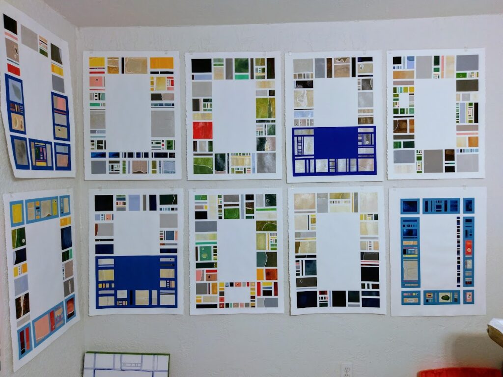 A group of oil paintings on paper, arranged on the wall of a studio, by artist Joanna White.