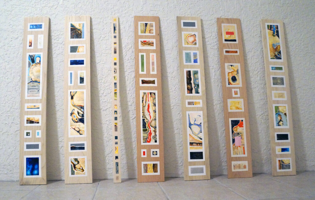 A row of narrow wooden boards with oil paintings applied in geometric blocks to the fronts.