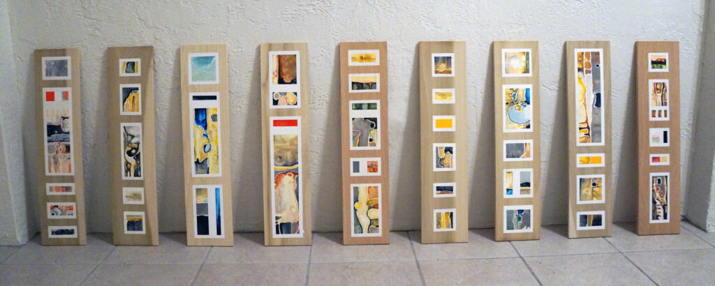 A row of narrow wooden boards with segmented geometric oil paintings applied to the front by artist Joanna White.